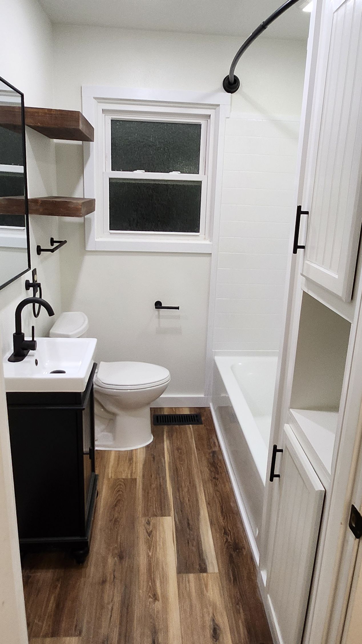 A bathroom with a toilet , sink , and bathtub.