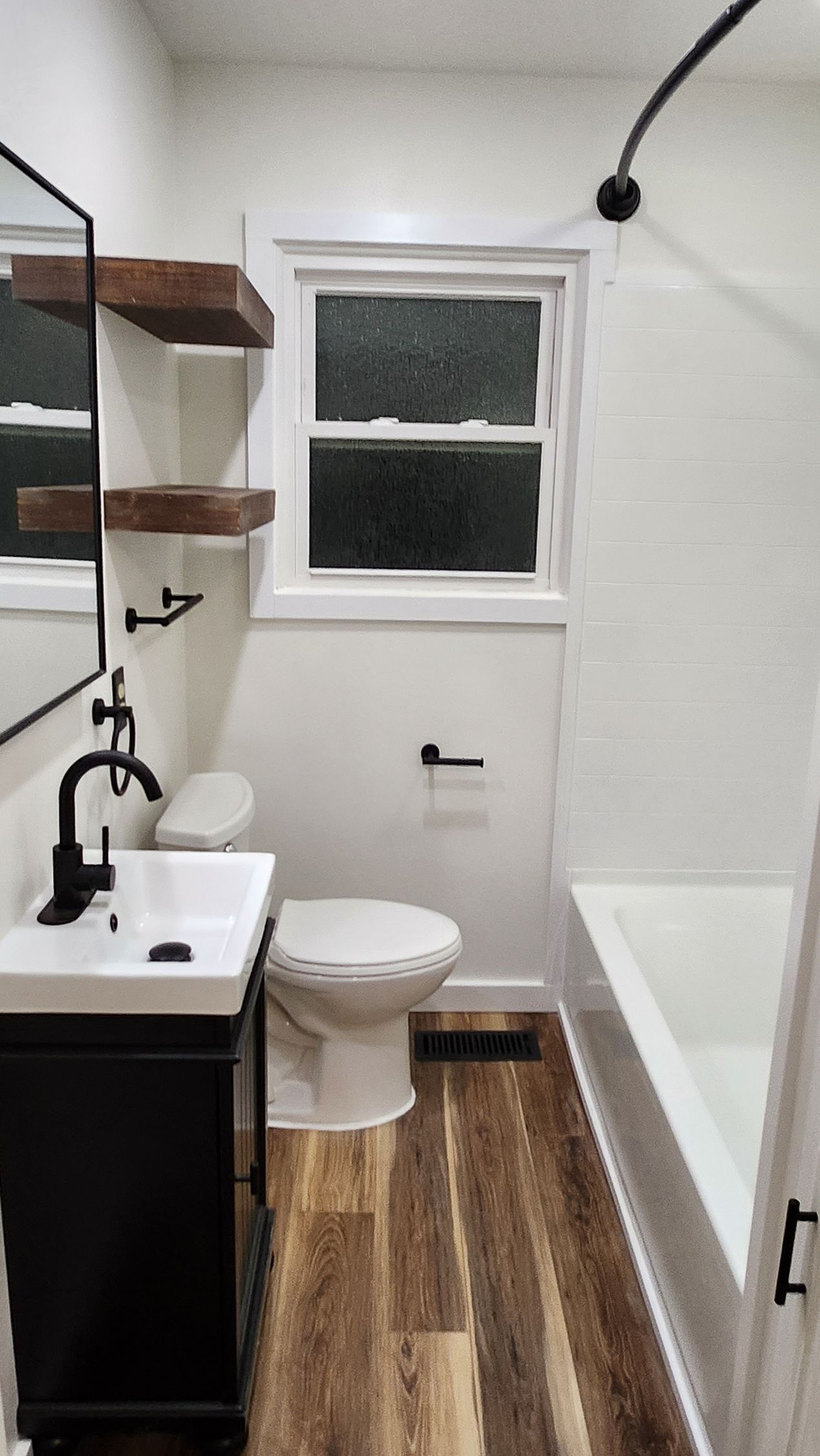 A bathroom with a toilet , sink , and bathtub.