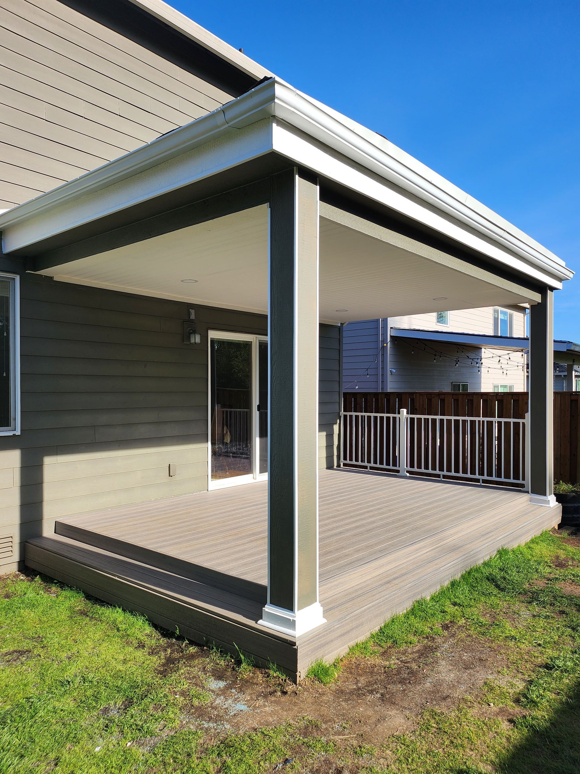 A house with a covered deck and a fence