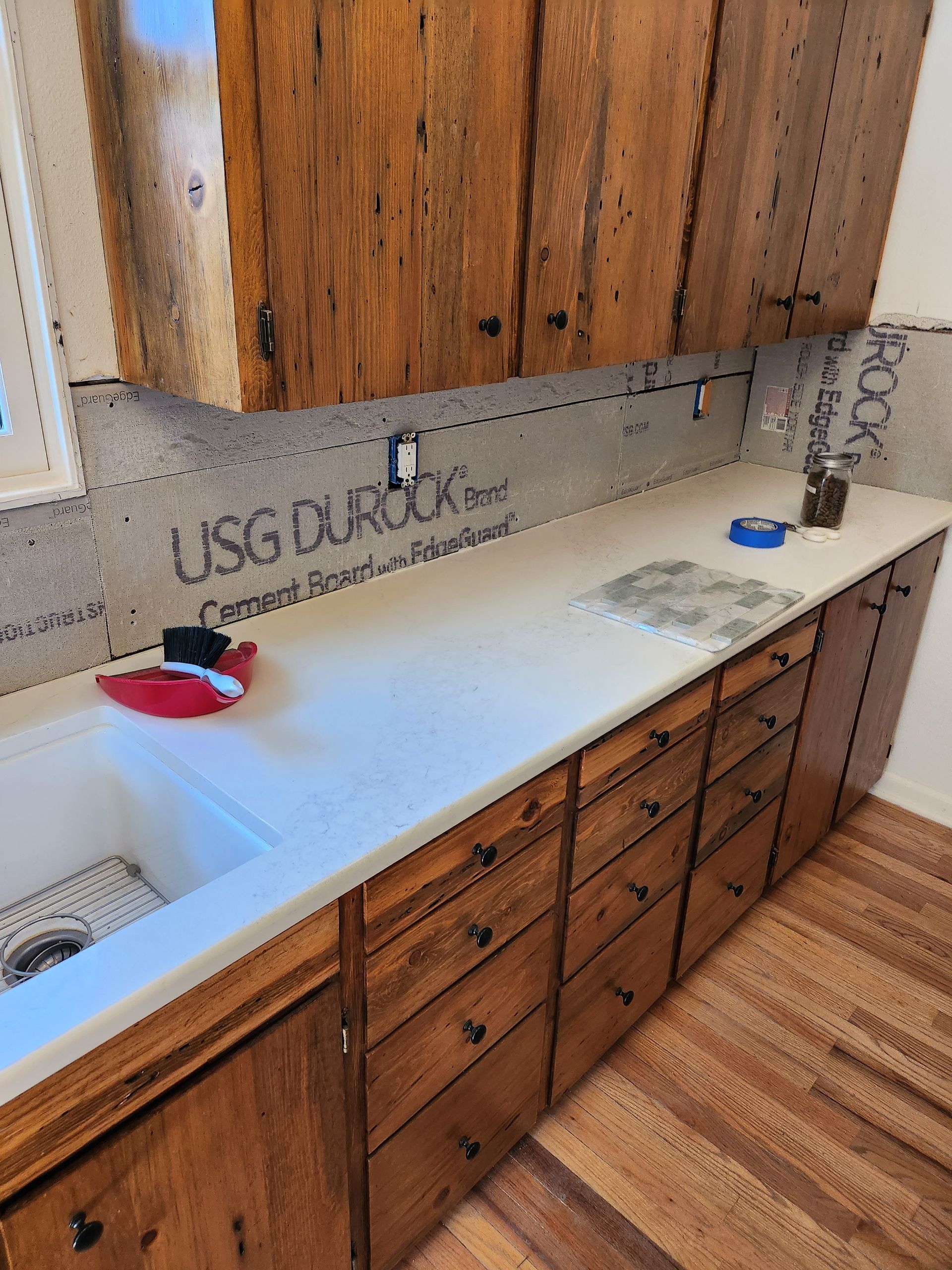 A kitchen with wooden cabinets and a white counter top
