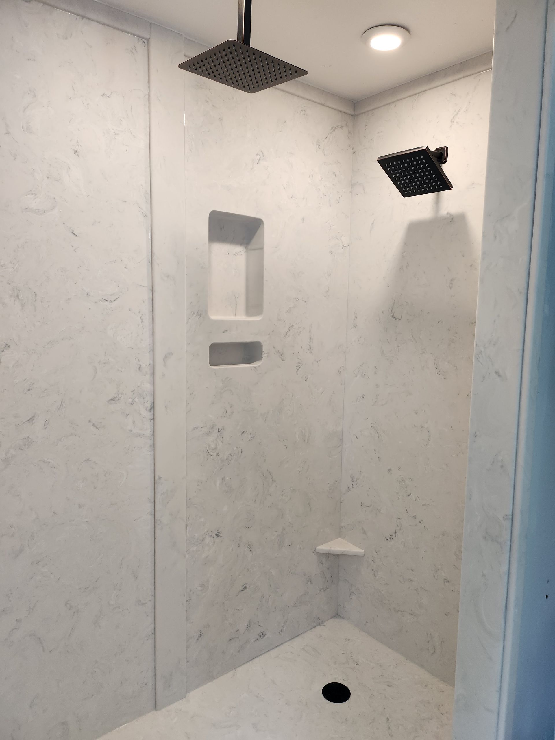 A white shower with a black shower head