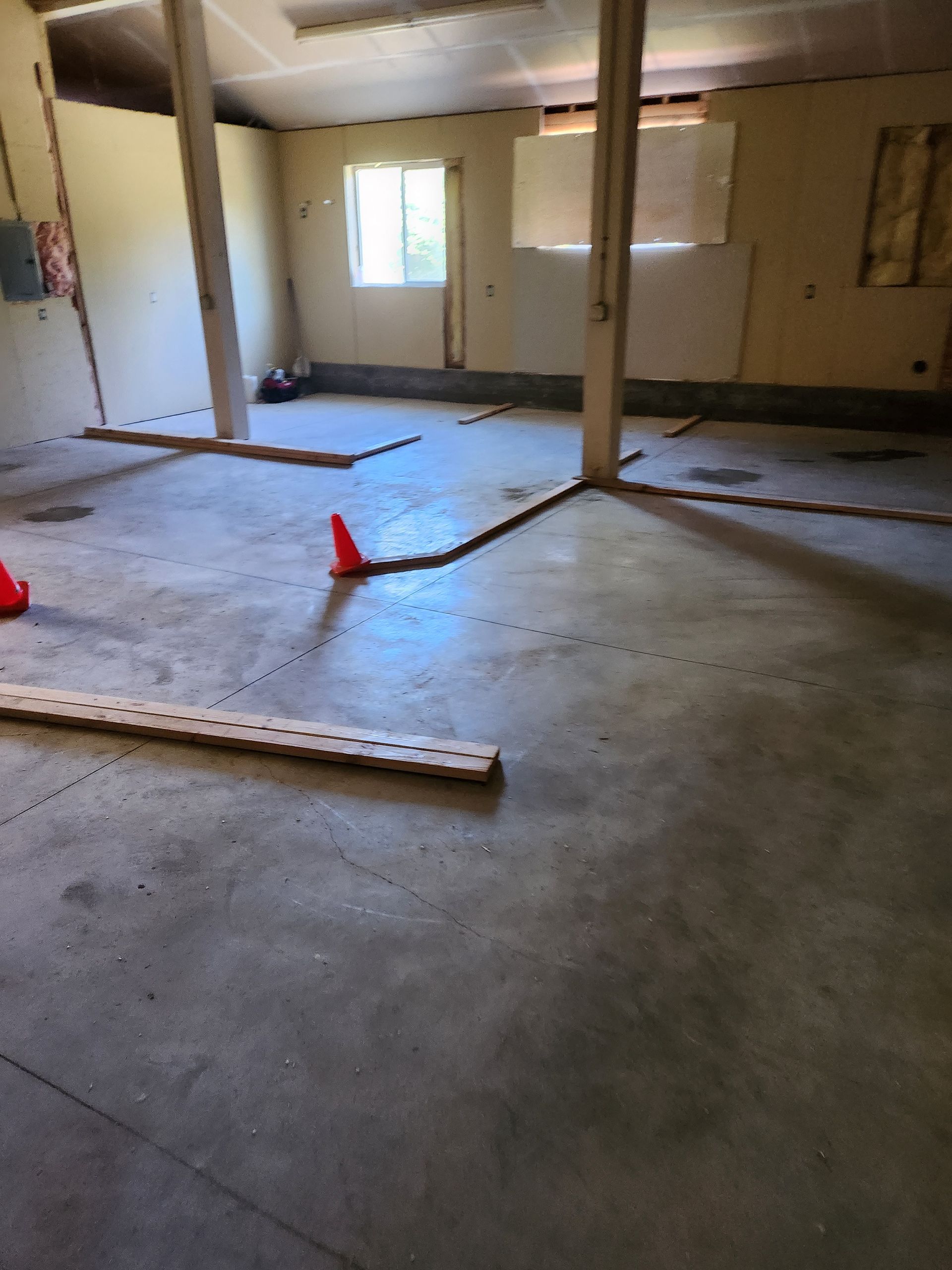 An empty room with a red cone on the floor