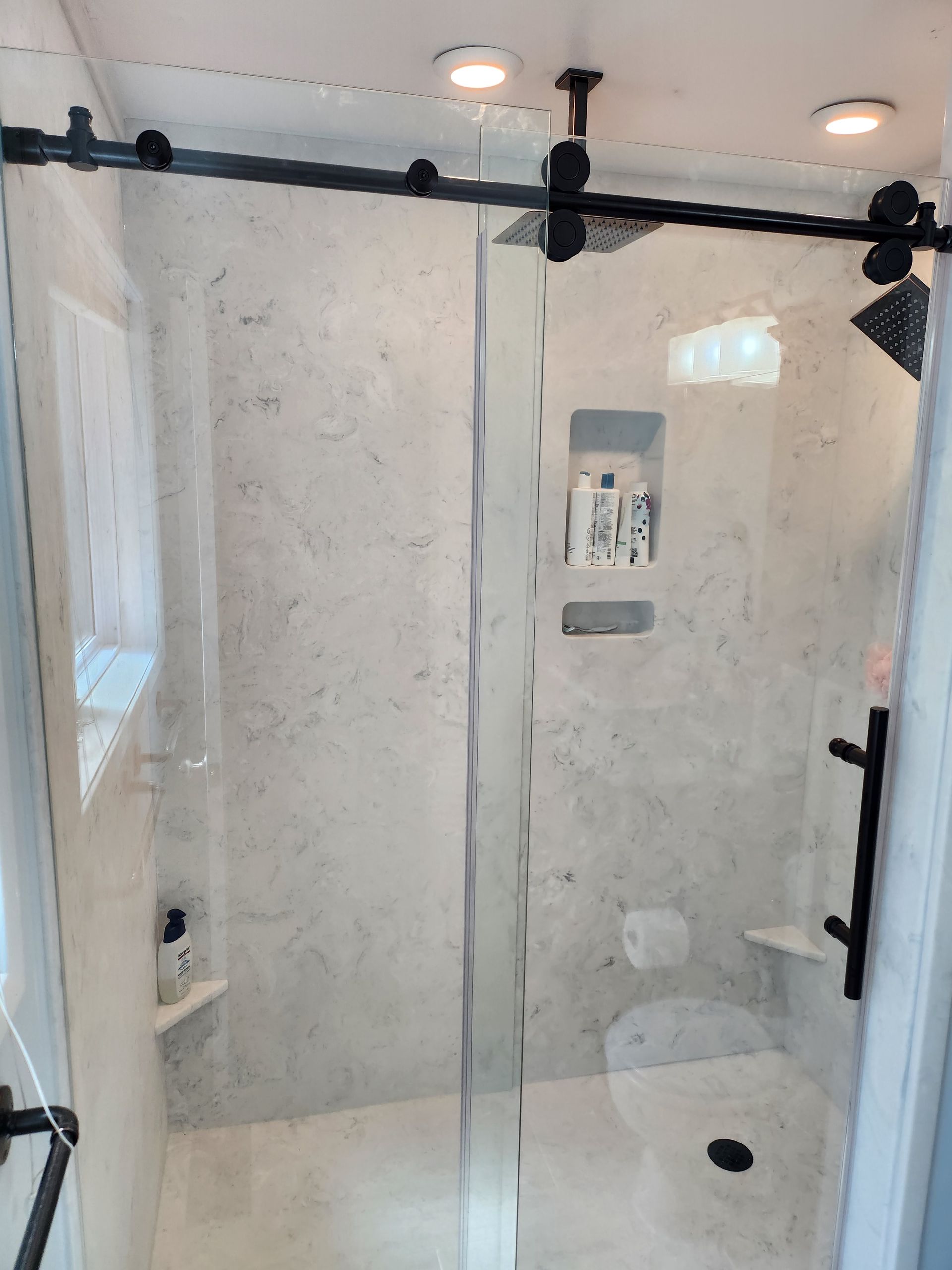 A bathroom with a sliding glass shower door and a toilet.