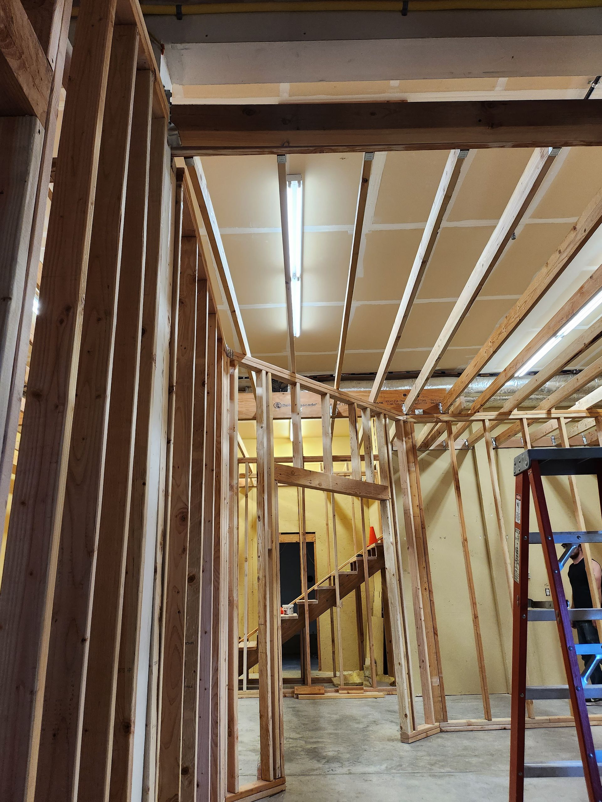 A person standing on a ladder in a building under construction