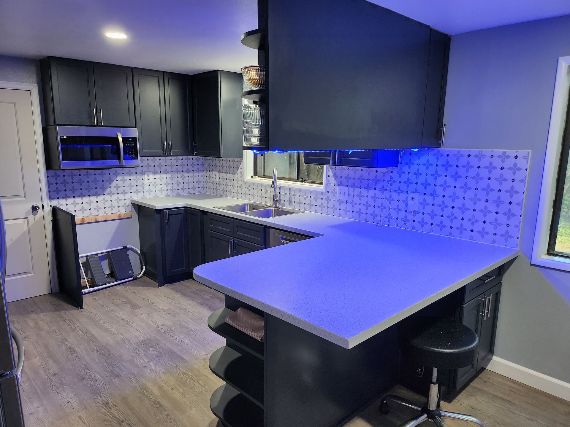 A kitchen with black cabinets and a blue counter top.