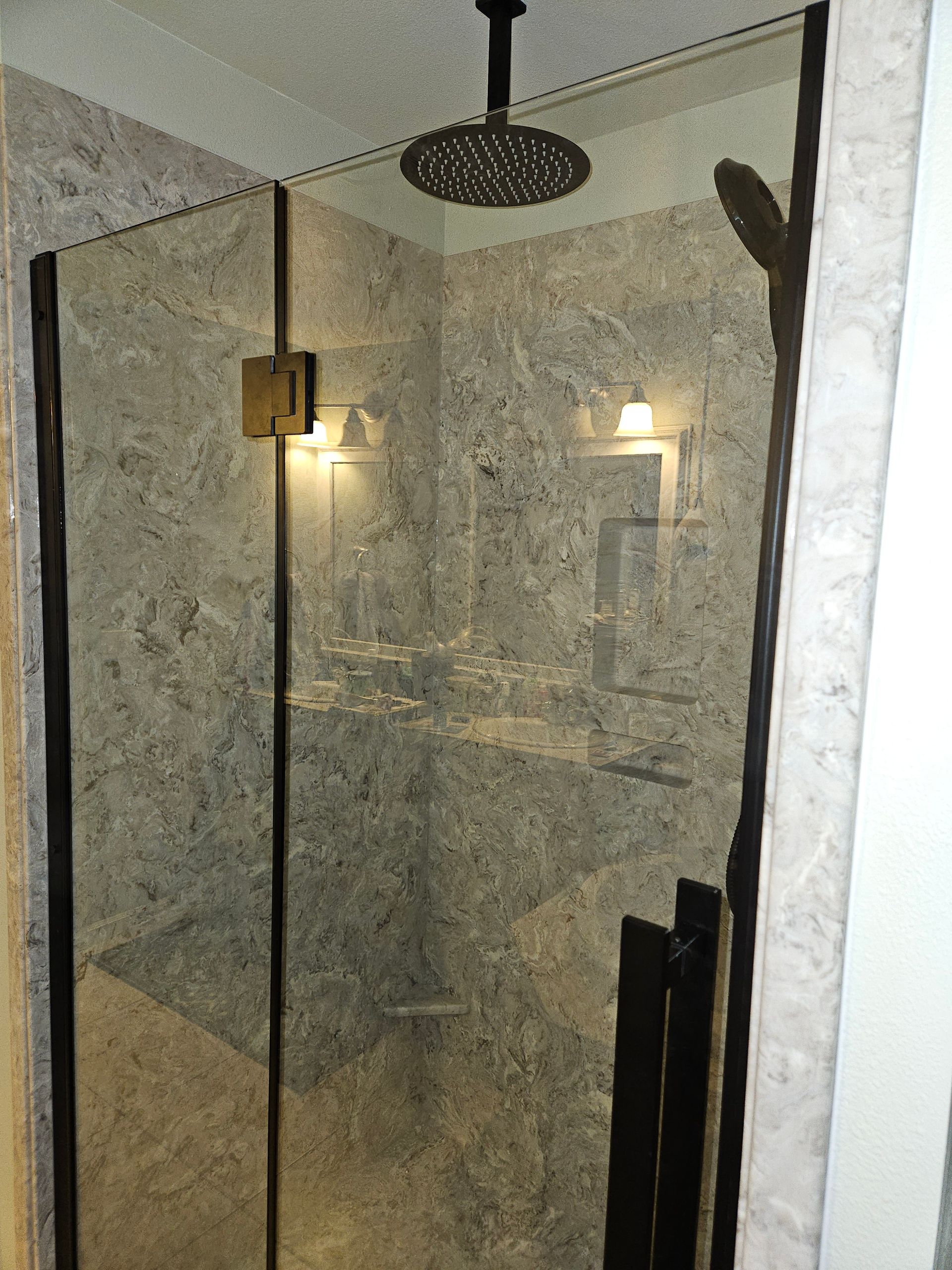 A bathroom with a walk in shower and a shower head