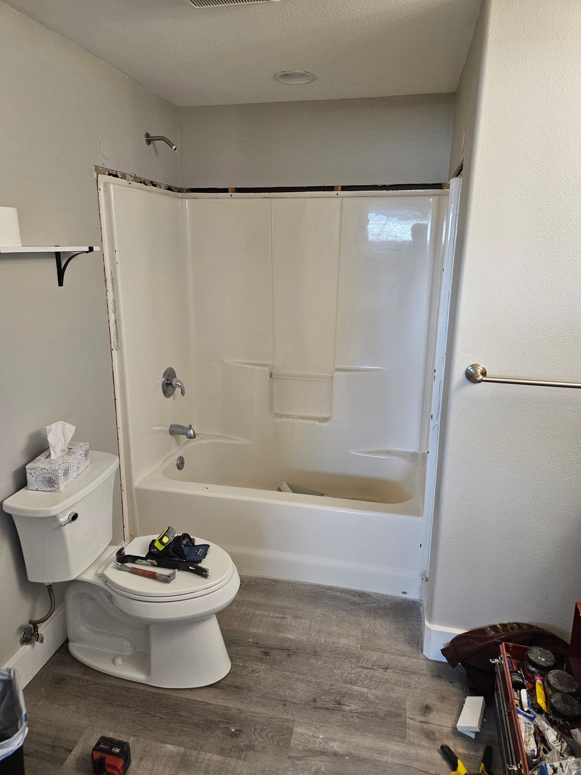 A bathroom with a toilet , bathtub and shower.