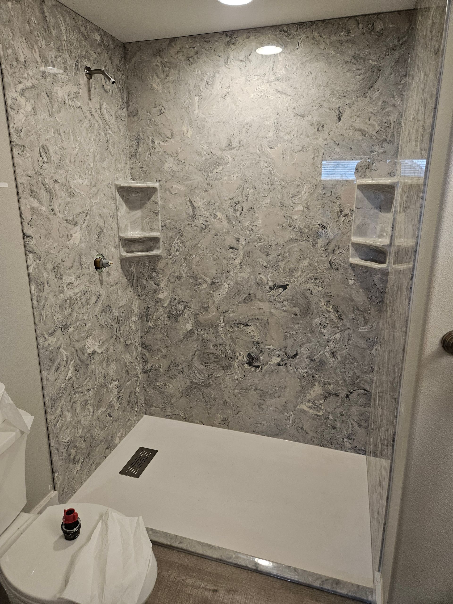 A bathroom with a walk in shower and a toilet.