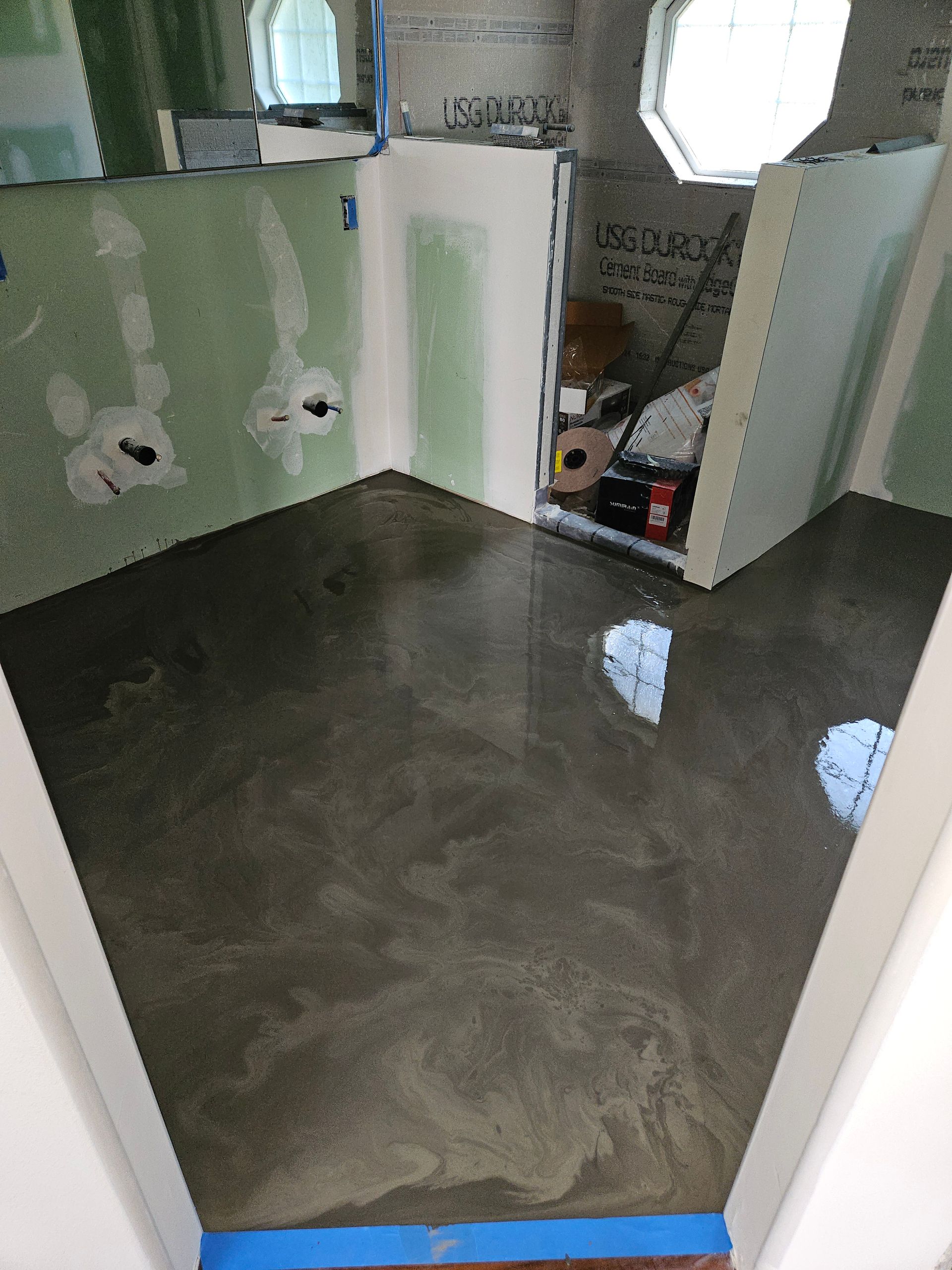 A room that is being remodeled with a shiny concrete floor