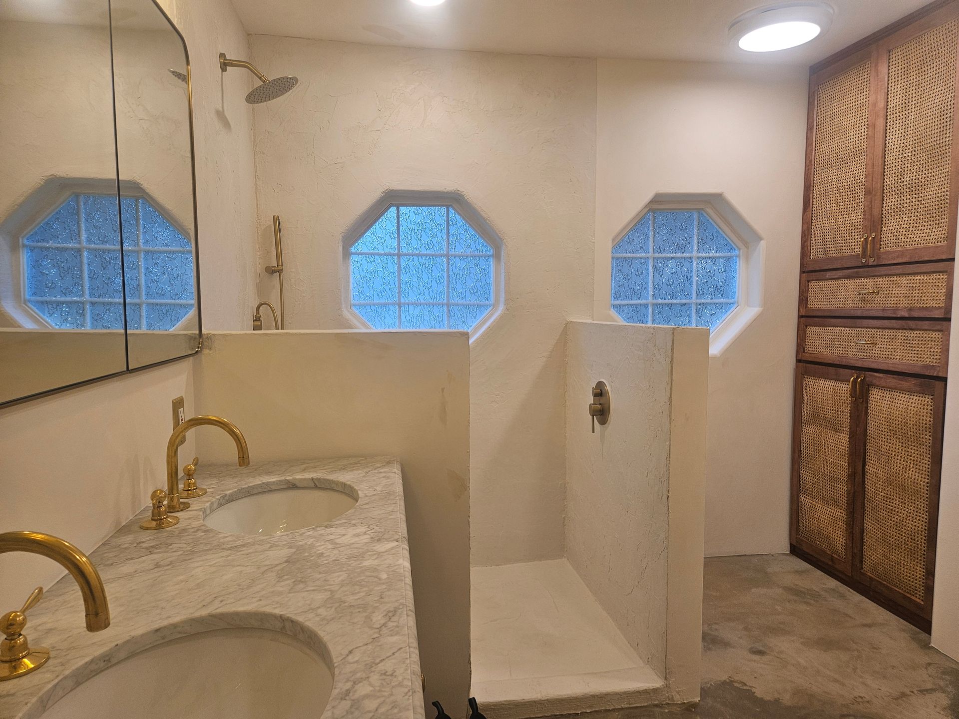 A bathroom with two sinks and a walk in shower.