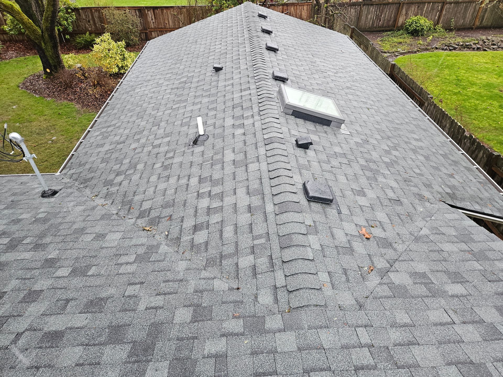 The roof of a house with a skylight on it.