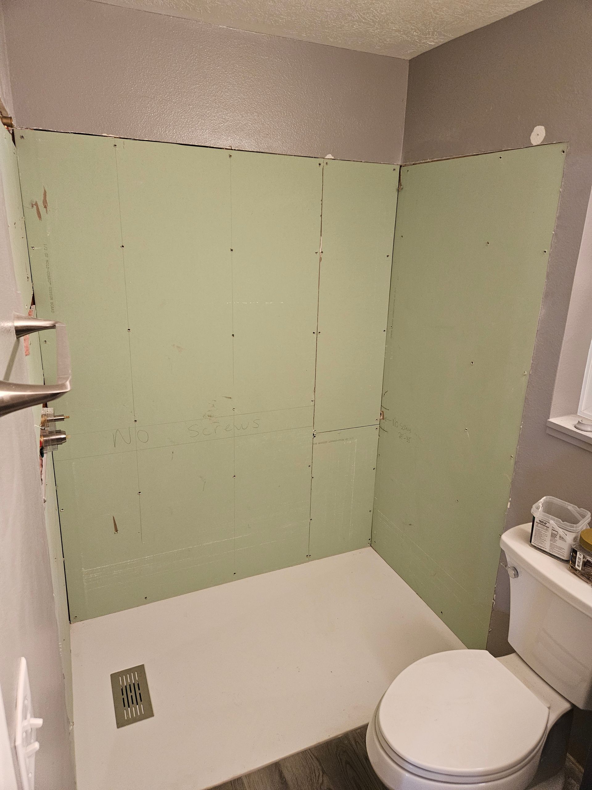 A bathroom with a toilet and a shower stall.