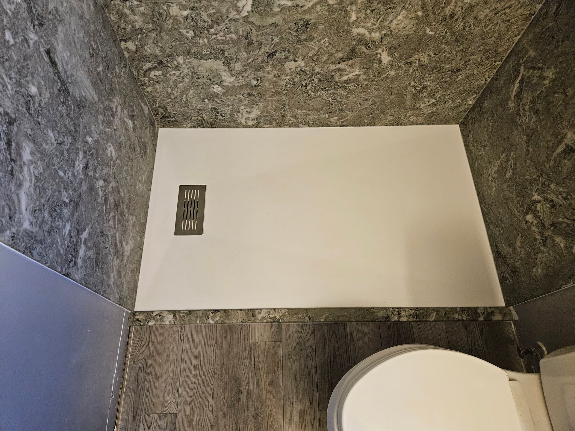 A bathroom with a toilet and a shower stall.