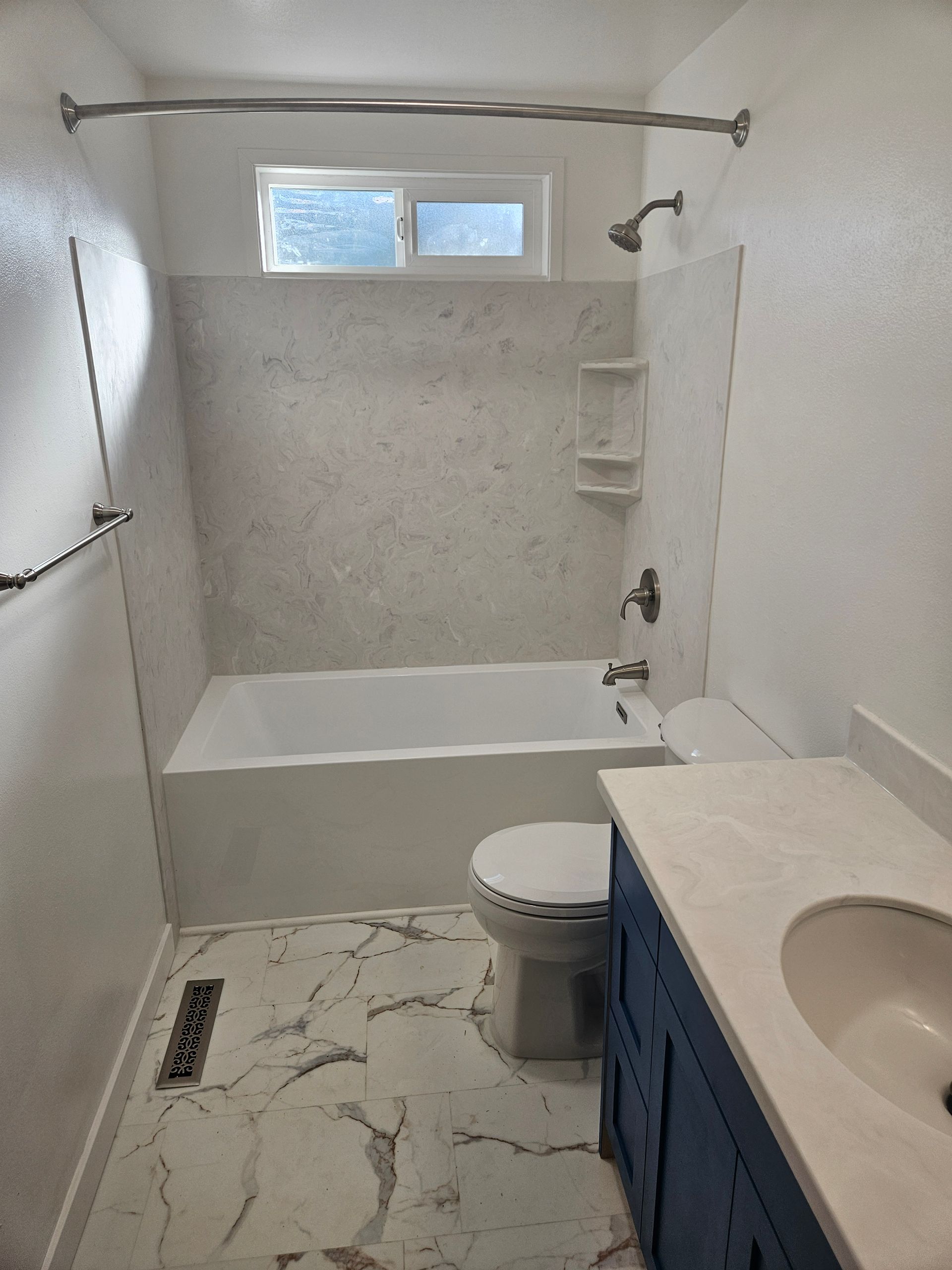 A bathroom with a tub , toilet , sink and shower.