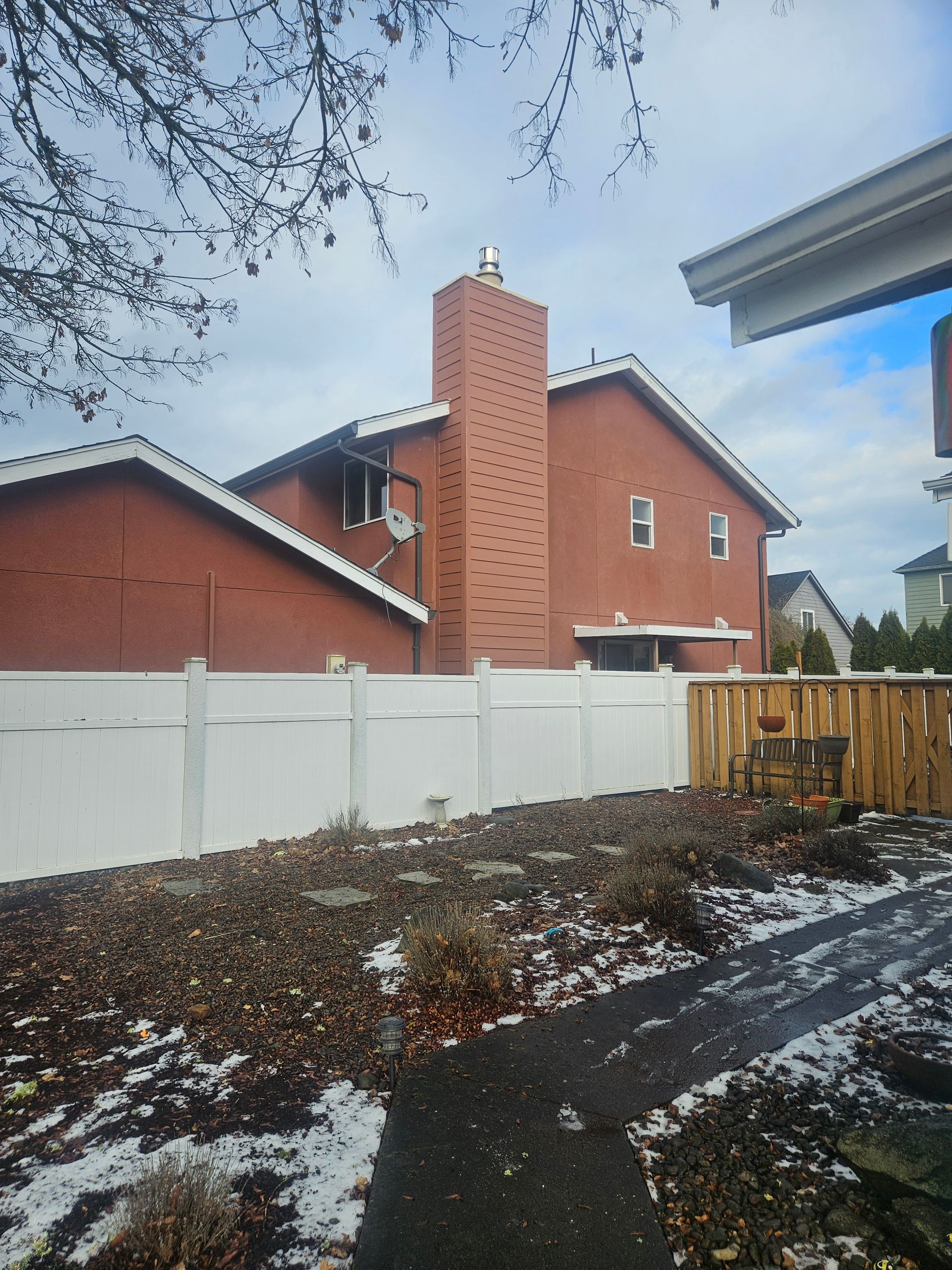 A brick house with a white fence in front of it