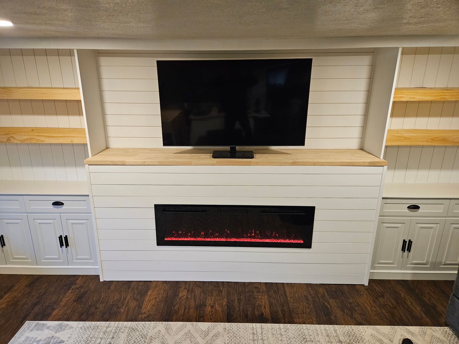 A living room with a fireplace and a flat screen tv.