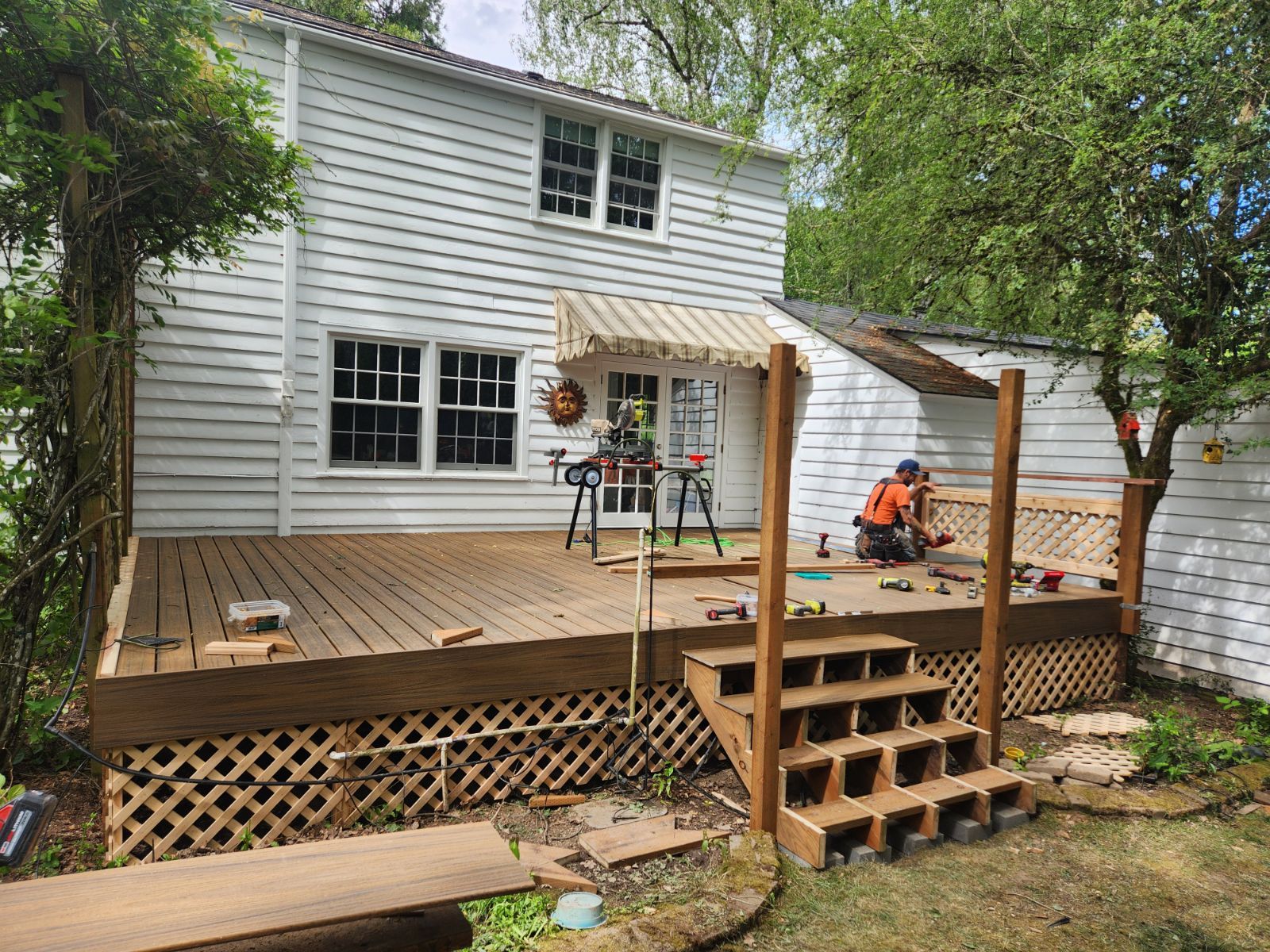 A wooden deck is being built in the backyard of a house.