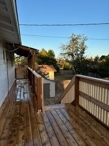 A wooden deck with stairs leading up to a house.