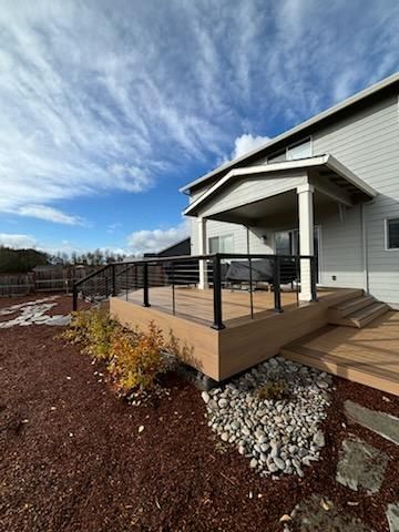 There is a deck with a railing in front of a house.