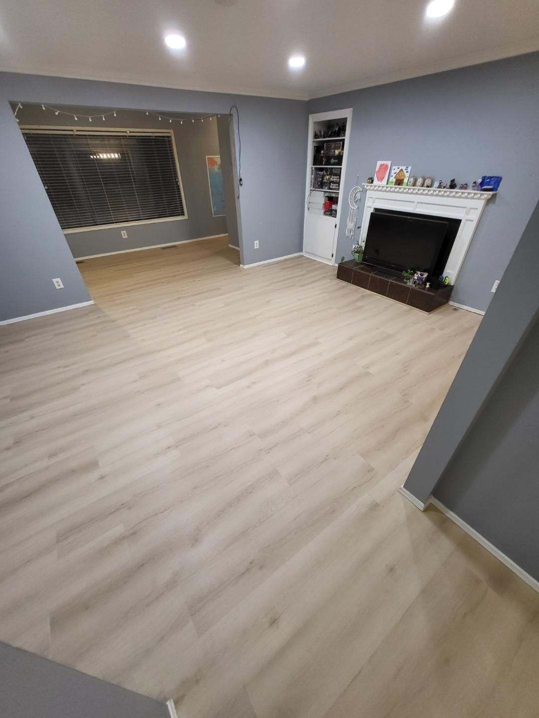 A living room with hardwood floors and a fireplace.