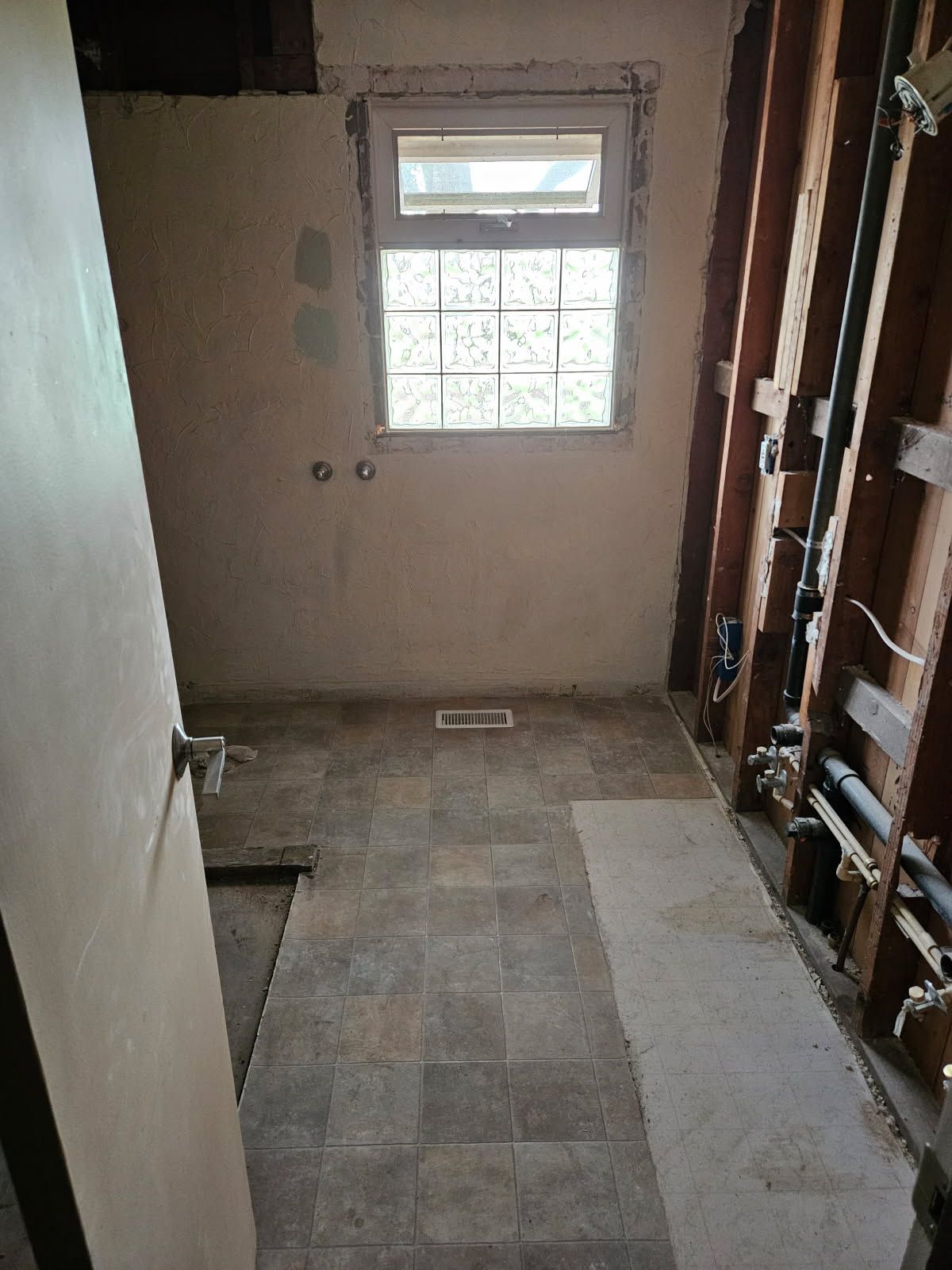A bathroom under construction with a window and a door.