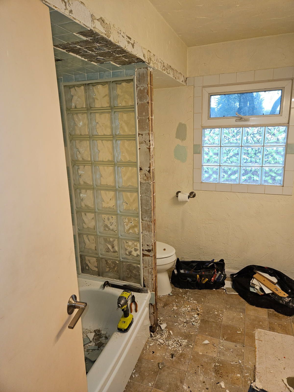 A bathroom with a tub a toilet and a window