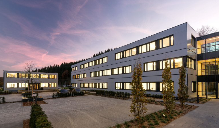 Ein großes Gebäude mit vielen Fenstern ist nachts beleuchtet