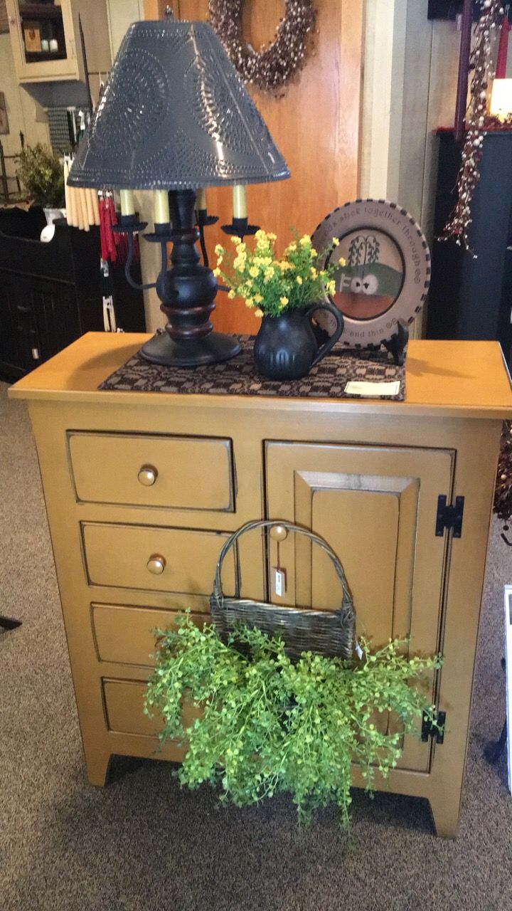 A lamp is sitting on top of a wooden dresser