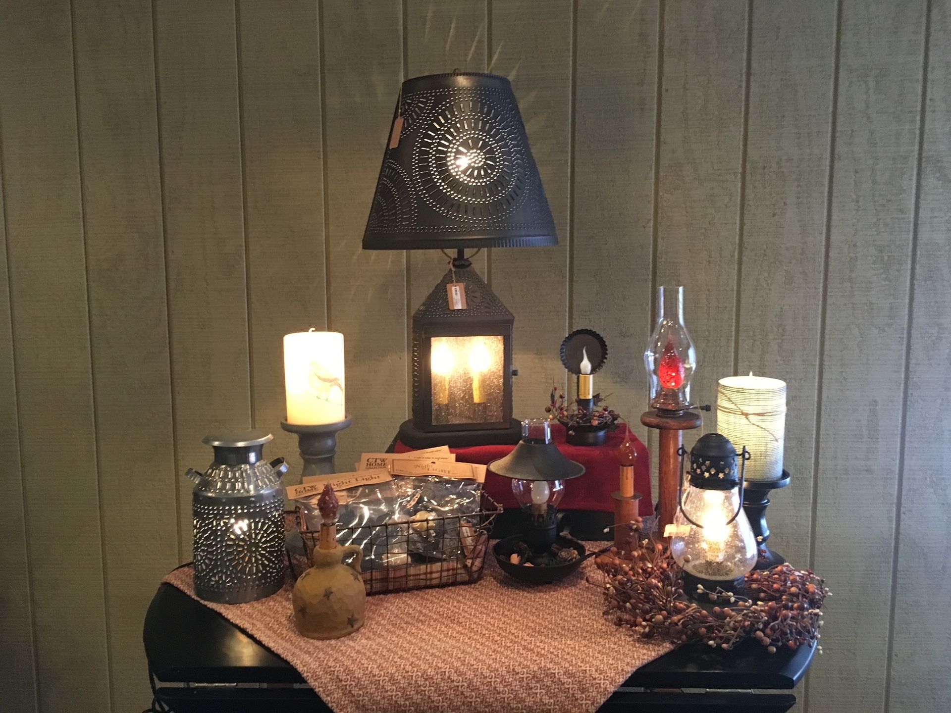 A table with a lamp and candles on it
