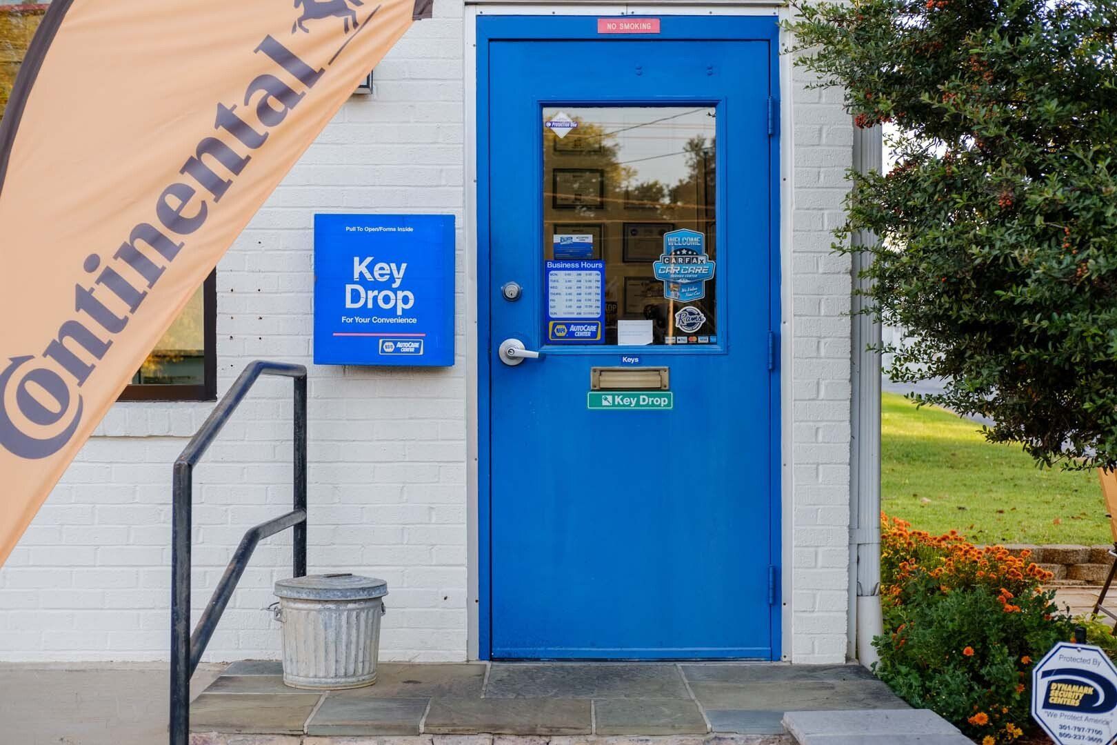 Blue service door with key drop box, Continental flag, and small trash can.