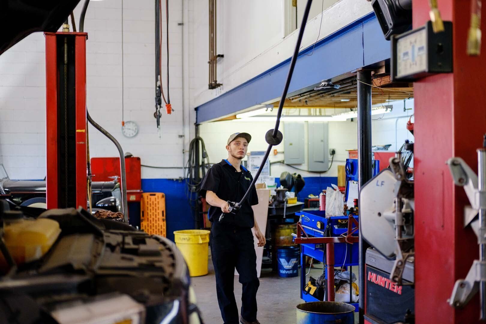 Mechanic in a car repair shop inspecting a vehicle.