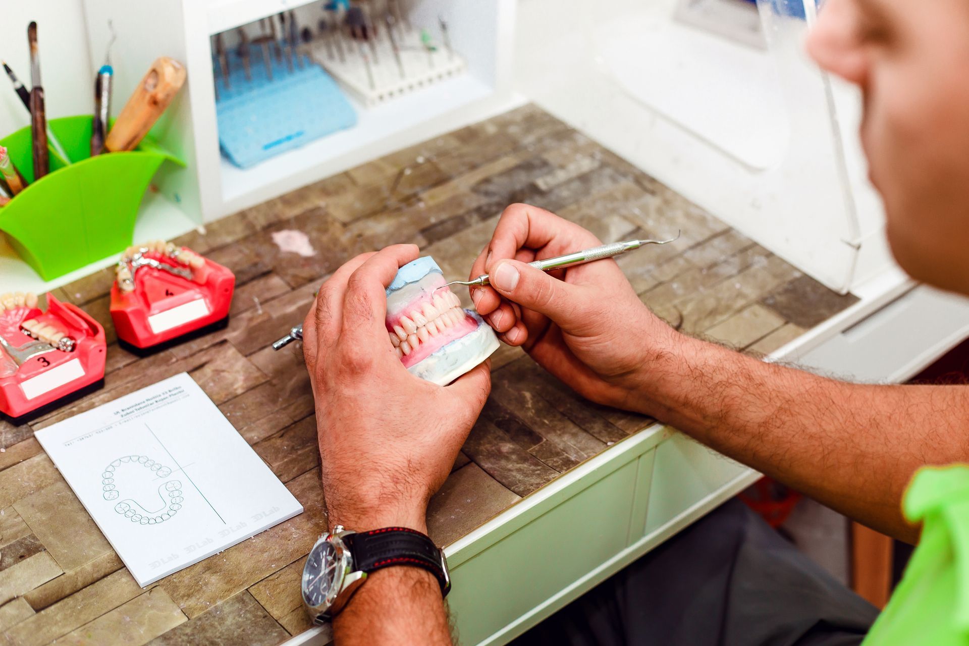 A dentist is working on a model of a person 's teeth.