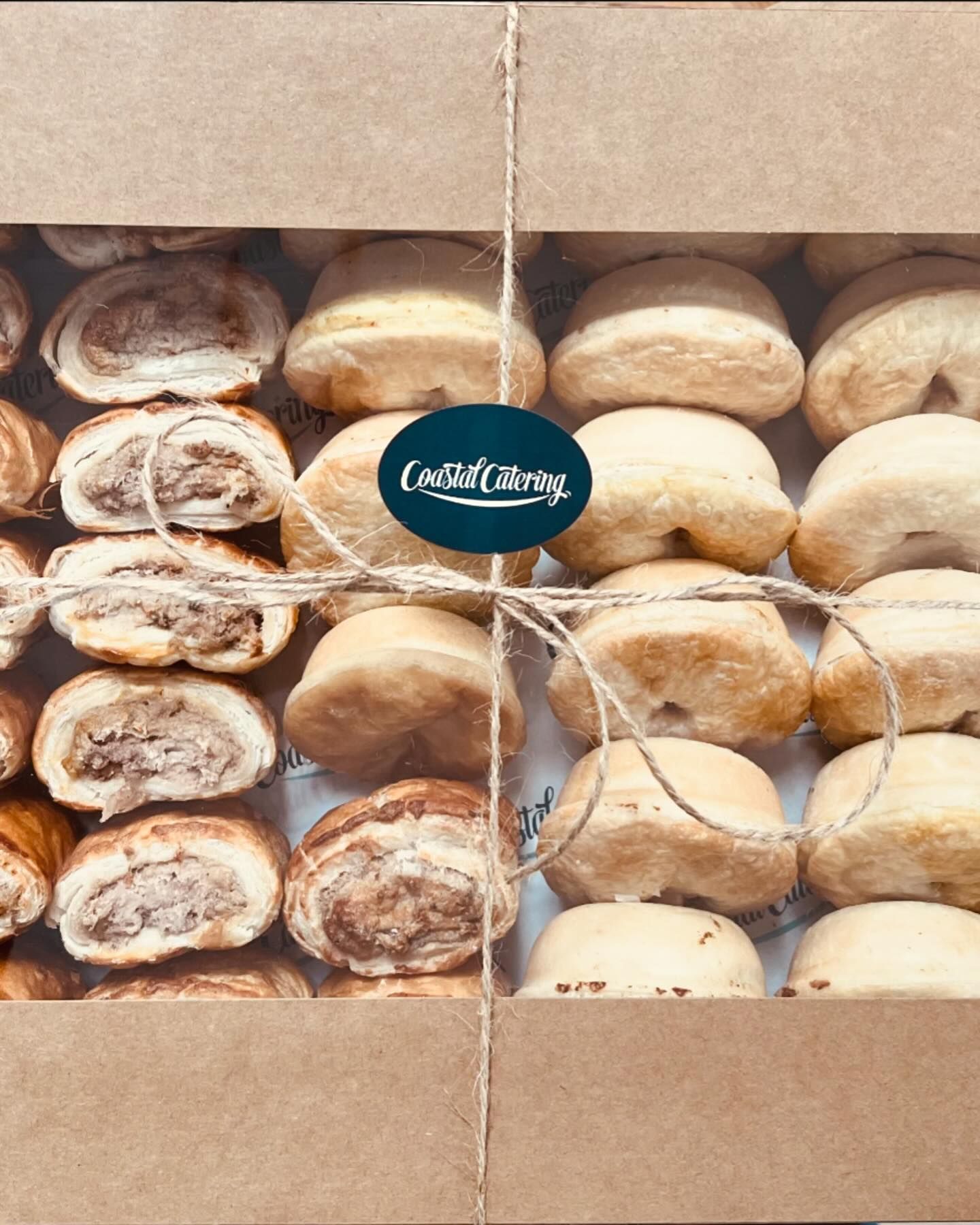 A box filled with a variety of pastries and rolls. — Coastal Catering in North Avoca, NSW