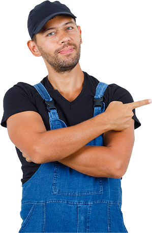 Man in blue overalls and black cap pointing right.