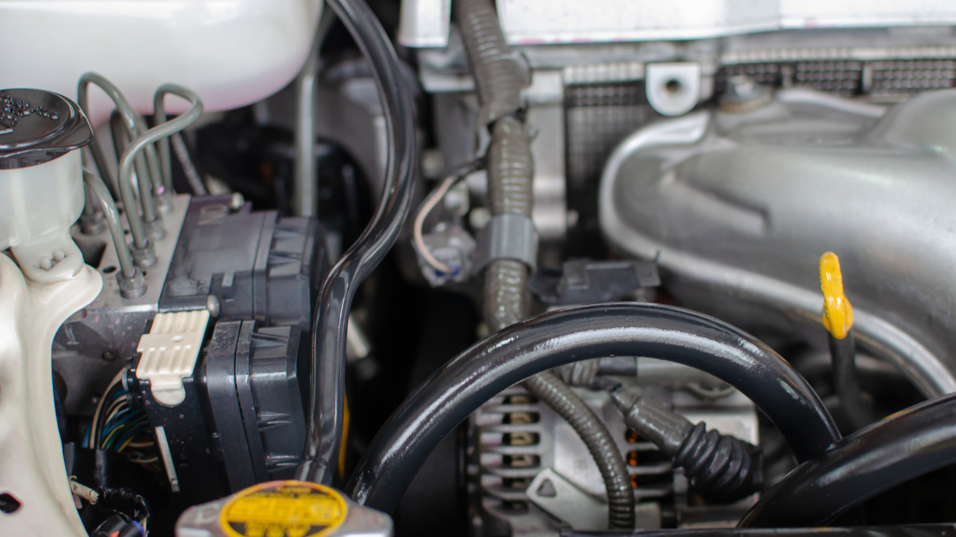 A close up of the engine of a car with the hood open.