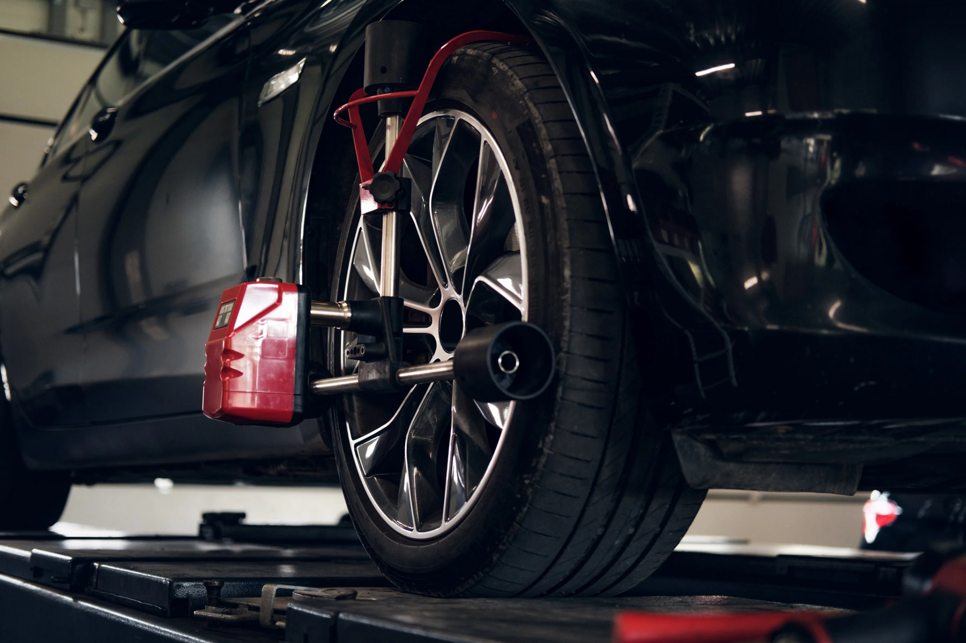 A car is being aligned on a lift in a garage.