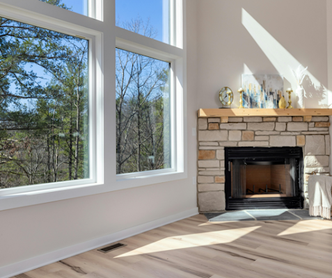 A living room with a fireplace and lots of windows.