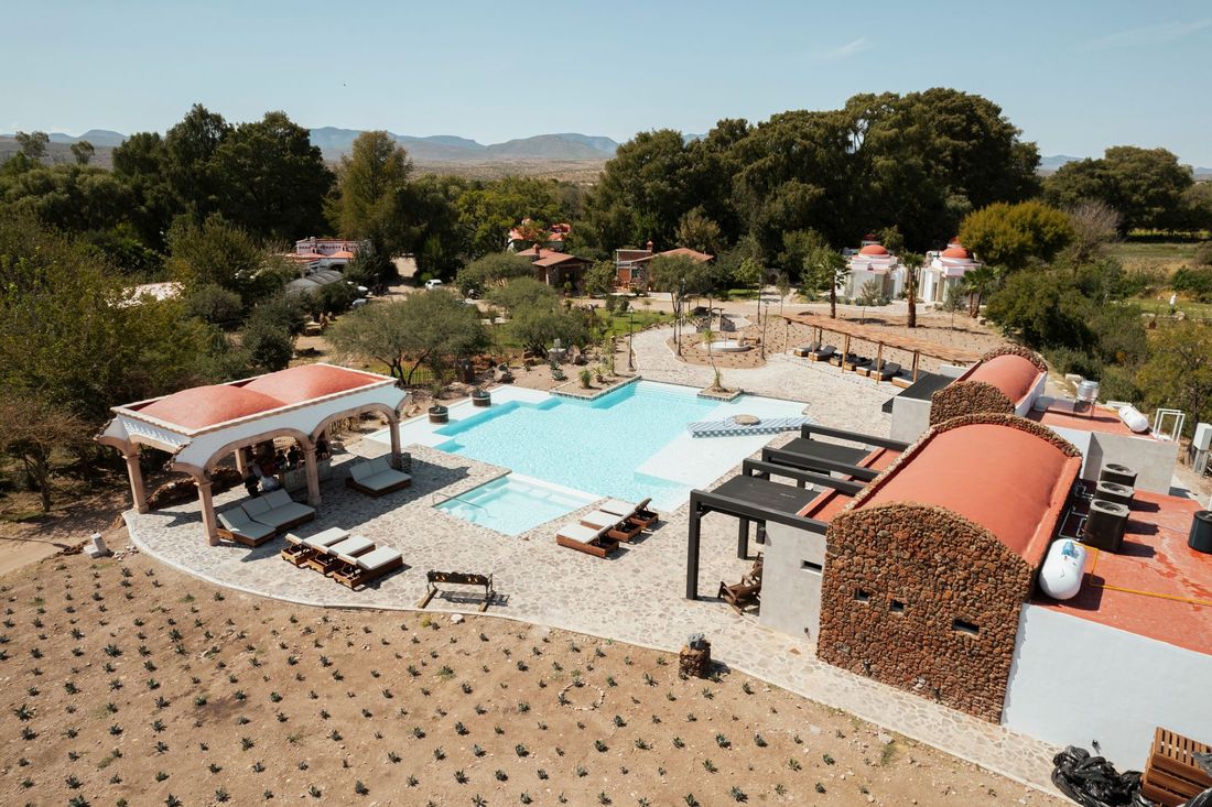 Vista aérea de la piscina de un complejo turístico con tumbonas.