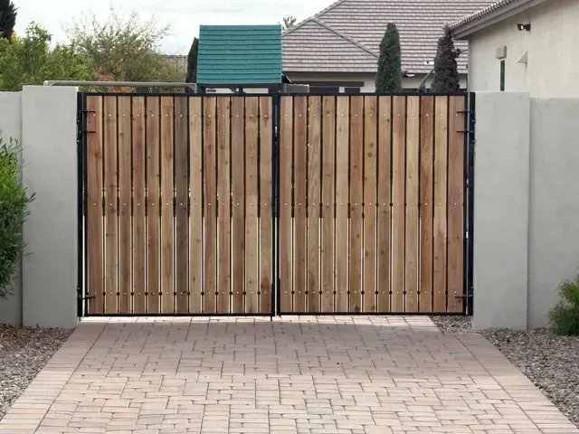 Wooden gate with concrete frame installed by masonry contractor
