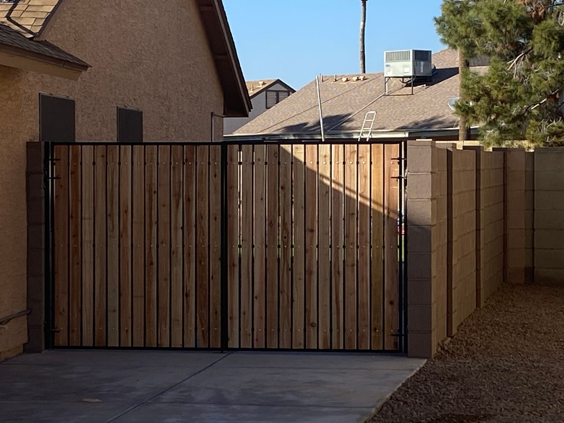 Wooden gate with concrete frame installed by masonry contractor