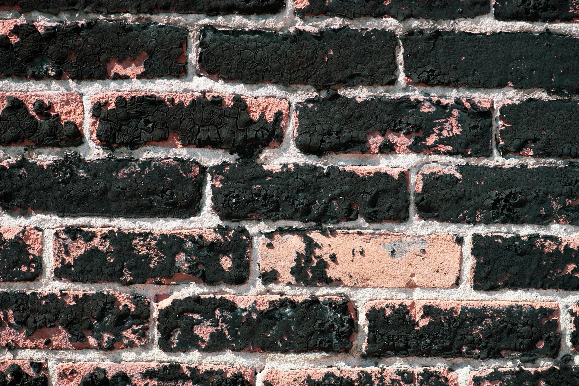 Damaged brick wall showing spalling and deteriorated mortar joints requiring professional repair