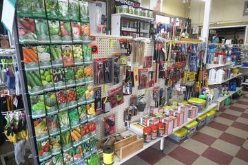 Interior view of a hardware store, showcasing seeds and tools on shelves. Store has checkered floors, and a variety of items on display — Farm and Home in Nabiac, NSW