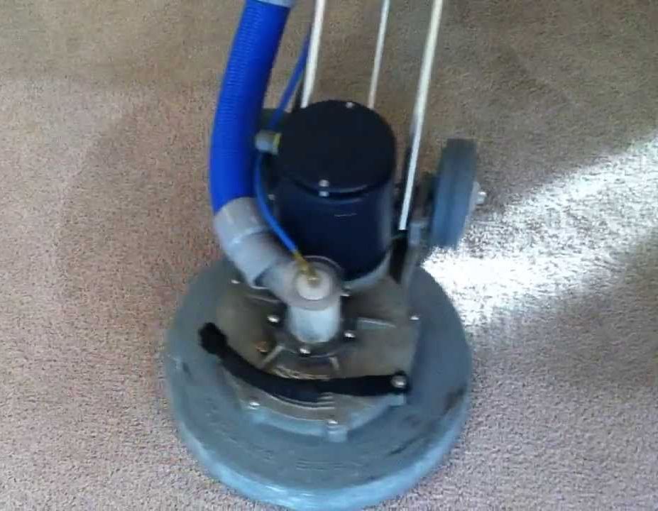 A vacuum cleaner is sitting on top of a carpet.