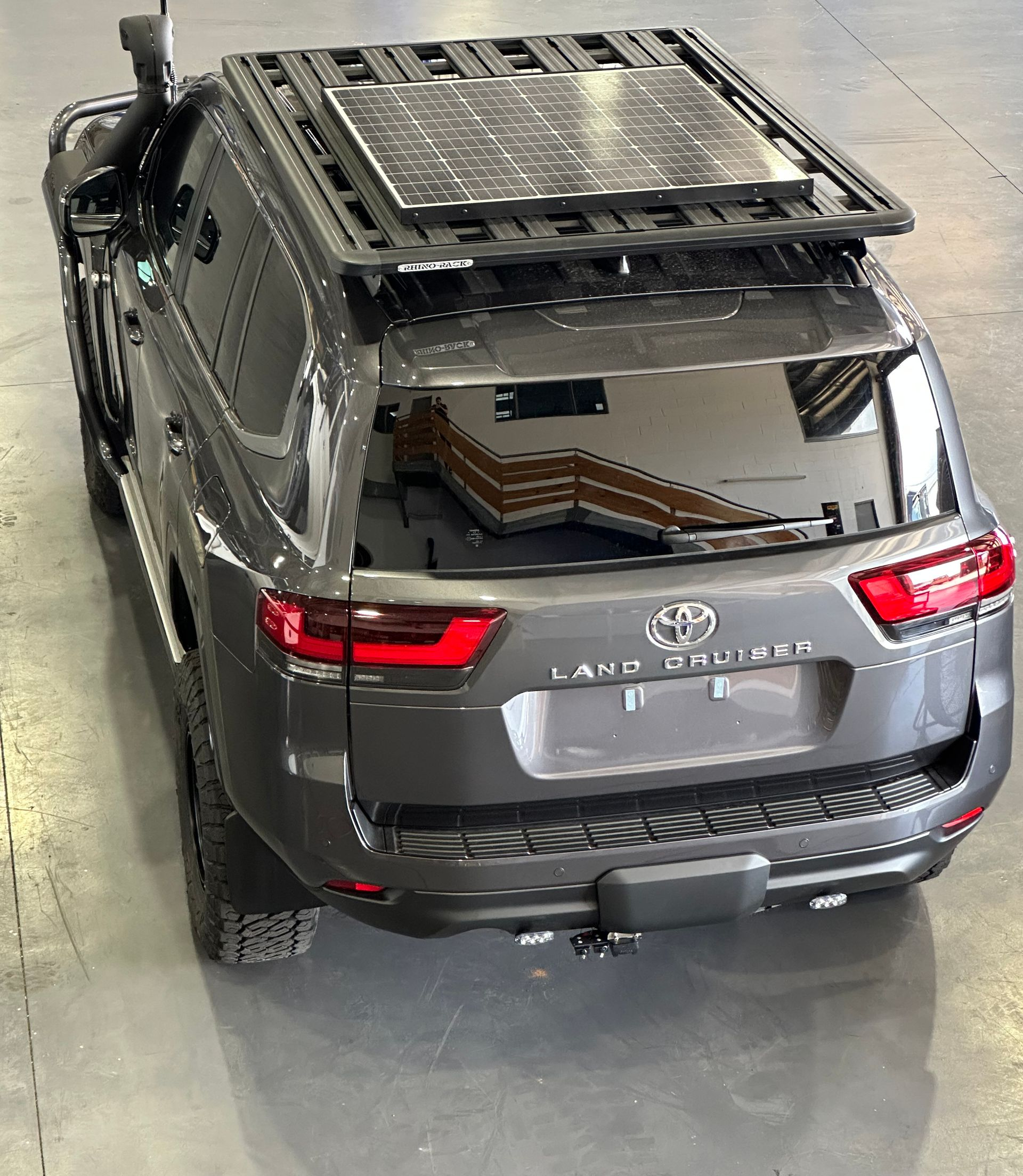 Silver SUV with a roof rack parked indoors in a garage or showroom, rear view.  — Outback Auto NT in Berrimah, NT