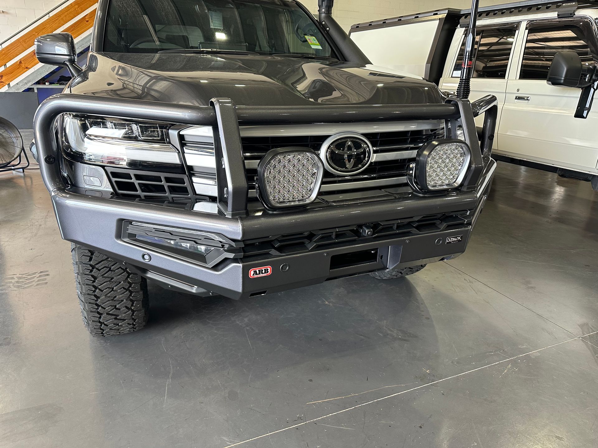 Black off-road pickup truck with a heavy-duty front bumper in a garage showroom.  — Outback Auto NT in Berrimah, NT