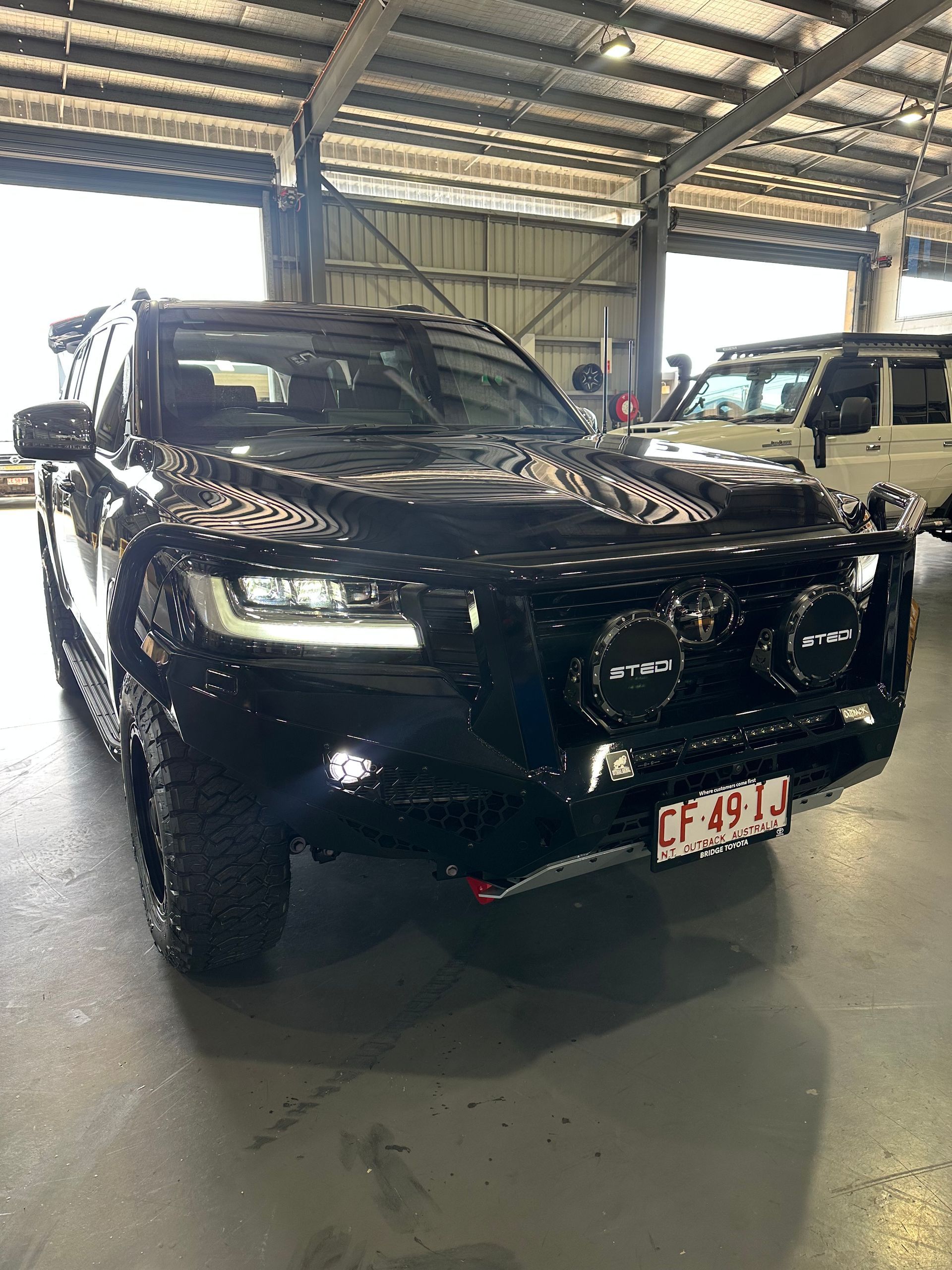 Black SUV parked under a covered structure, front view with headlights and a bull bar.  — Outback Auto NT in Berrimah, NT
