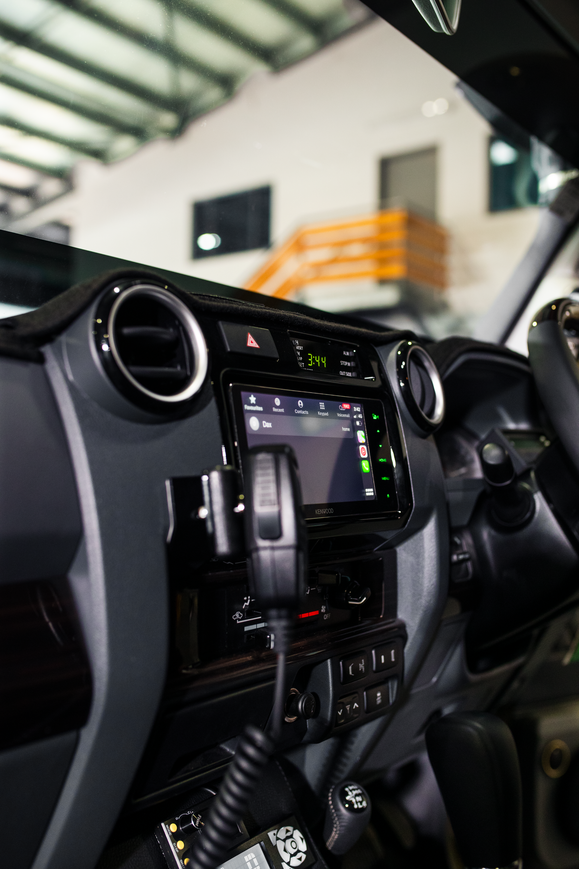 Car dashboard with central touchscreen and radio controls in a garage, shown in close-up. — Outback Auto NT in Berrimah, NT