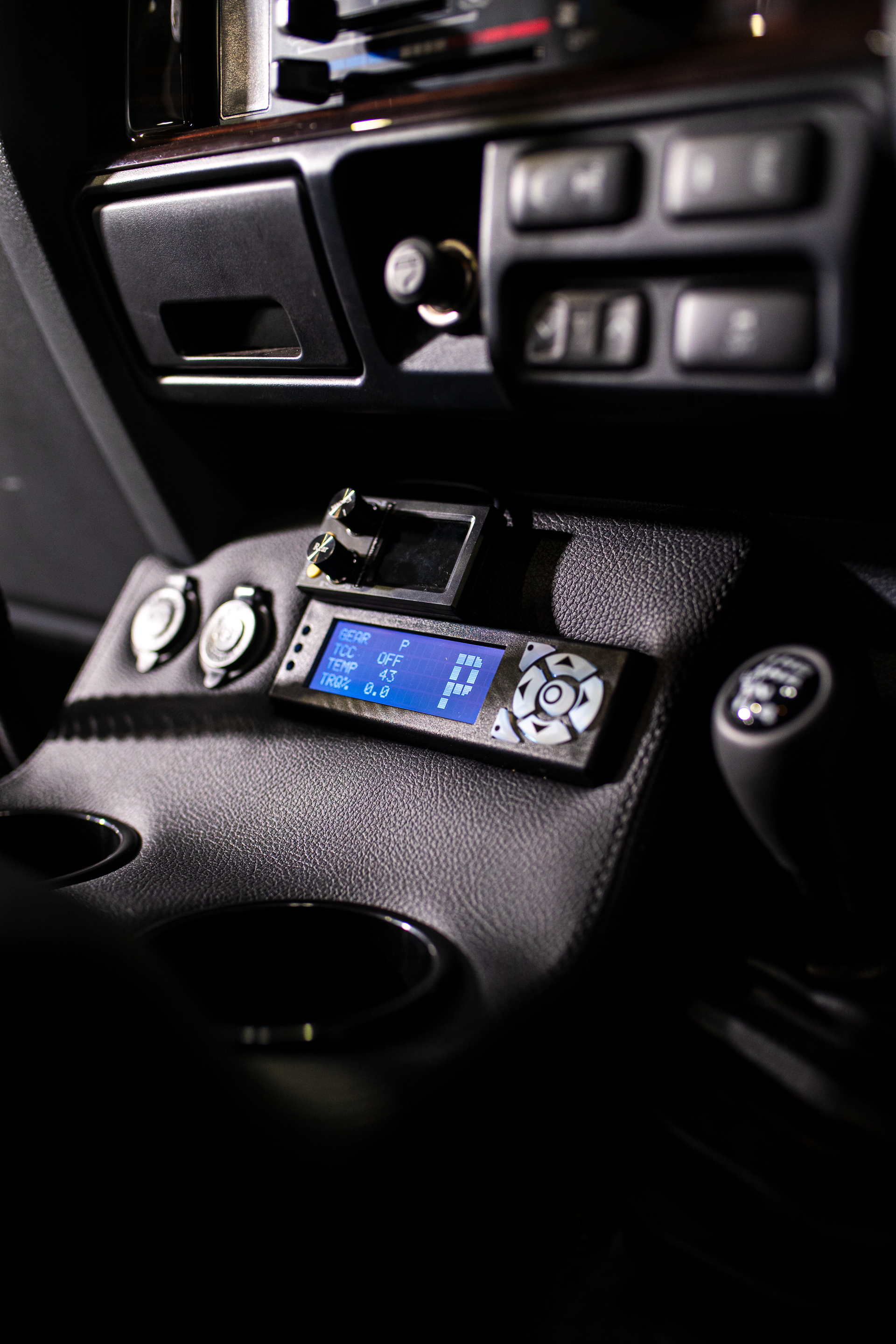 Compact blue-lit radio controller mounted in a car dashboard — Outback Auto NT in Berrimah, NT