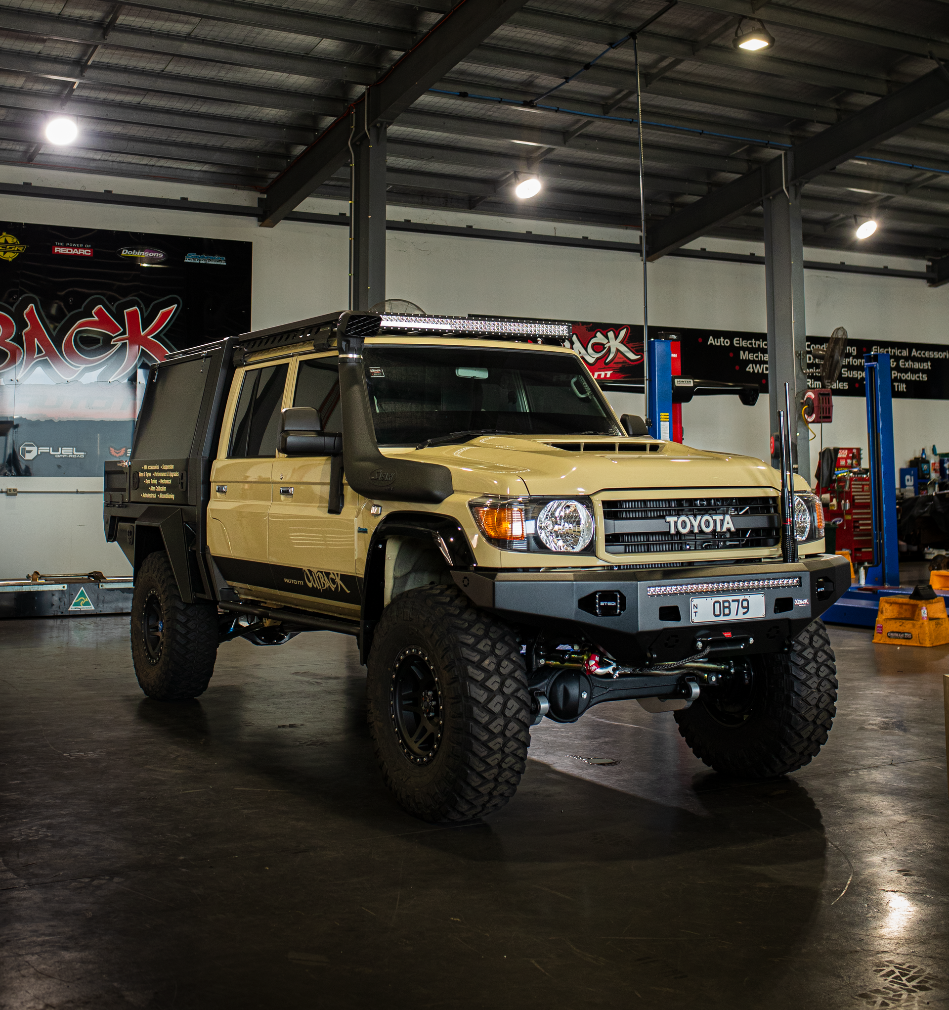 Lifted Toyota truck parked outside a modern building entrance. — Outback Auto NT in Berrimah, NT