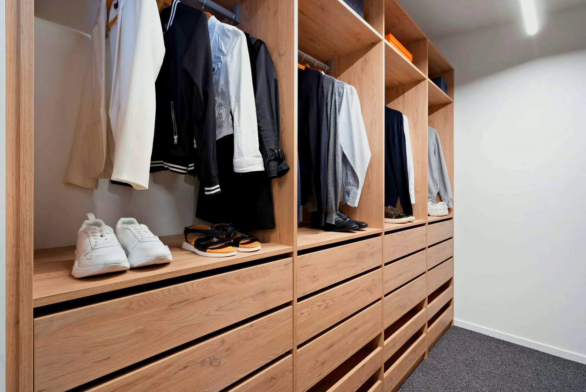 A walk in closet filled with clothes and shoes.